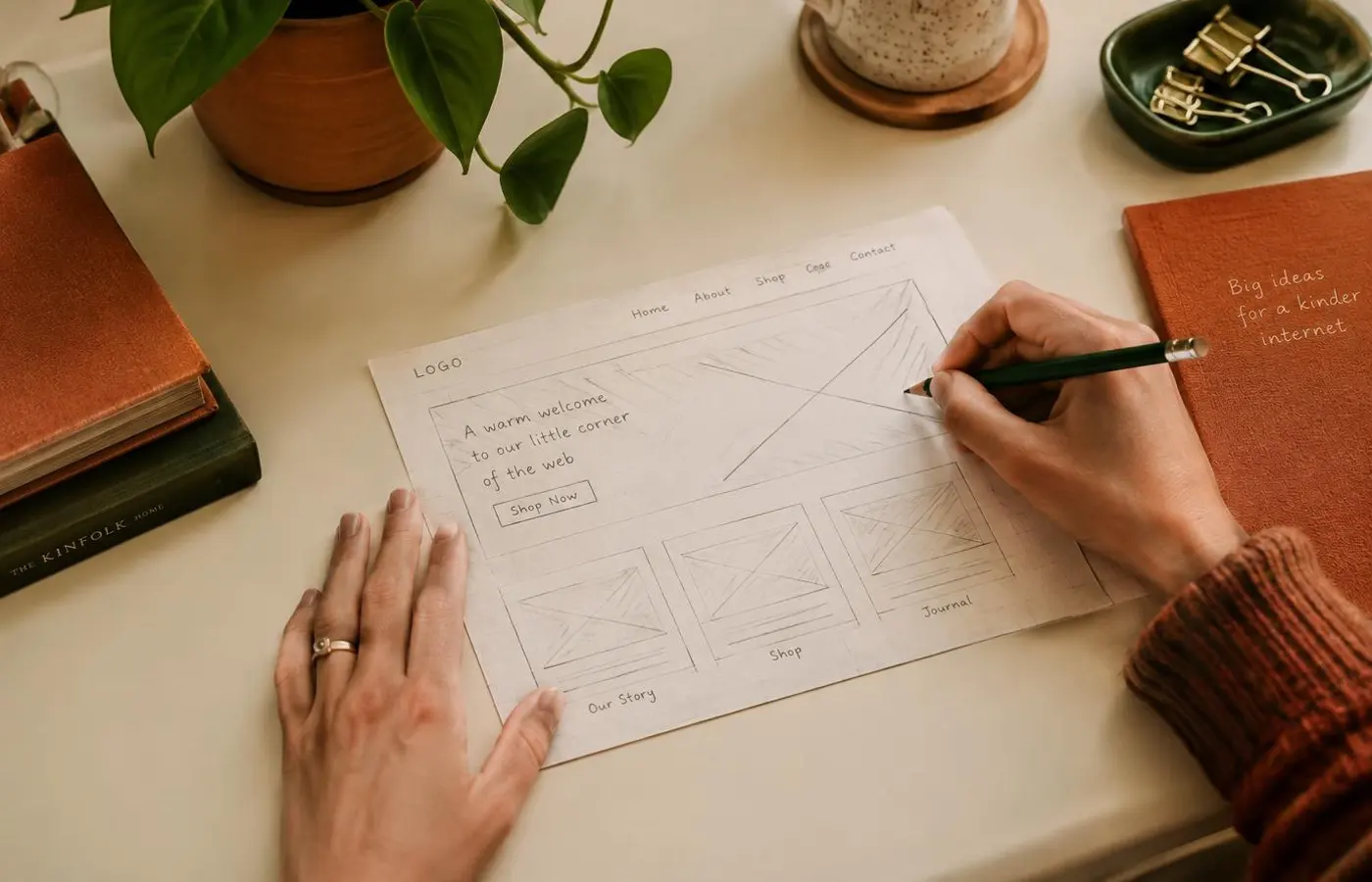 Hands sketching a website wireframe on paper